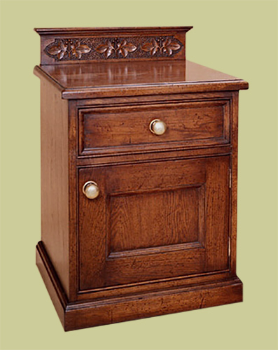 Bedside cabinet, handmade in oak, with upper drawer and carved up-stand to the back.