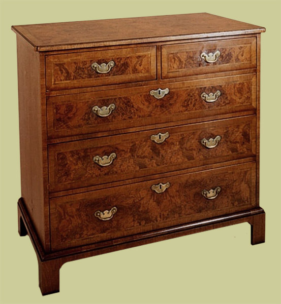 Walnut chest of drawers, beautifully veneered with cross banded top and drawer fronts, with solid brass handles.