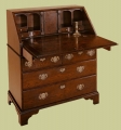 Traditional style oak bureau, shown open, with four drawers and a well under the writing flap.