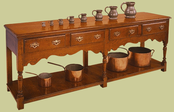 4 drawer dresser base with planked potboard, turned supports, shaped apron and solid brassware.