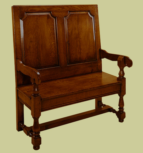 A joined oak settle with turned front legs and side stretchers.
