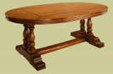 Oak oval dining table on hand carved paired pedestal bases