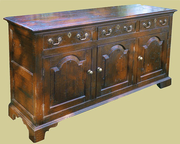 Oak 3 drawer dresser base with 18th century style arch top fielded door panels and cockbeaded drawers.