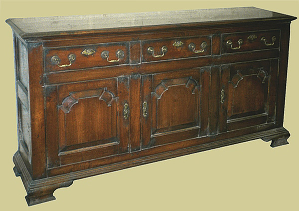 Oak 3-drawer closed dresser base with 3 fielded panel doors and attractive shaped bracketed feet.