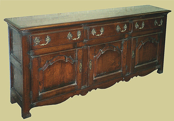Oak dresser base in French Provincial style. Typical Gallic design features include the shaped fielded doors.