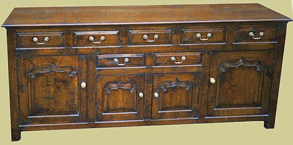 Oak 7 drawer dresser base, with fielded drawer fronts and 4 ogee shaped fielded panel doors.