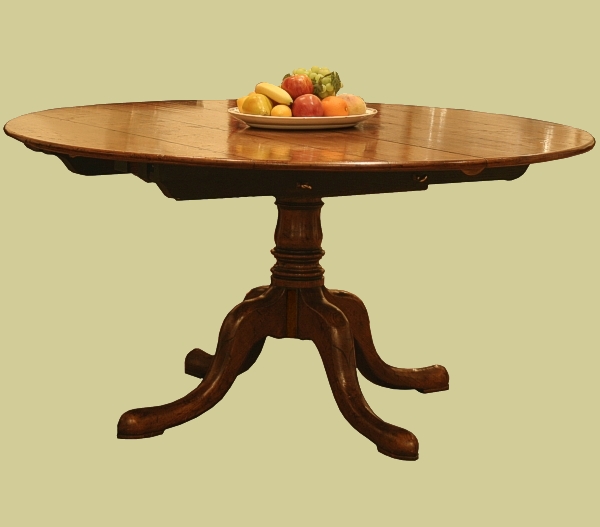 Extending oak pedestal table with round top