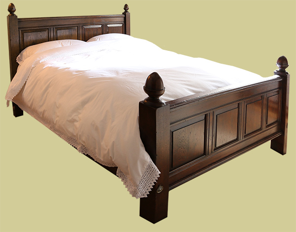Oak panelled bed with fielded panels and acorn turned finials
