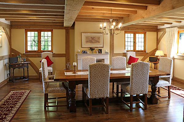 Heavy oak baluster turned extendable dining table and upholstered chairs, in oak framed room
