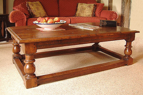 Traditional style baluster leg oak coffee table in period room setting.