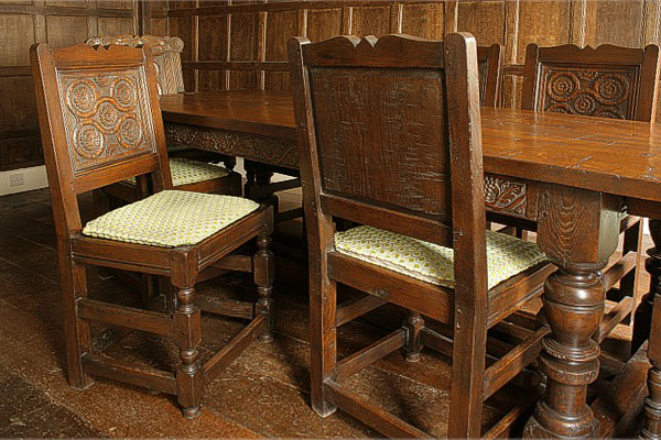 Hand carved Westmorland style oak side chairs in Tudor panelled dining room.