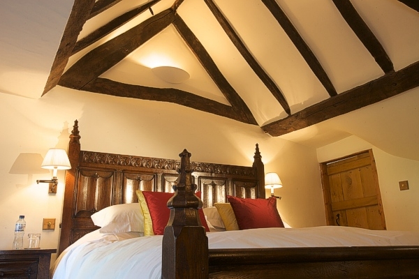 Carving detail of Tudor style bed in oak beamed bedroom