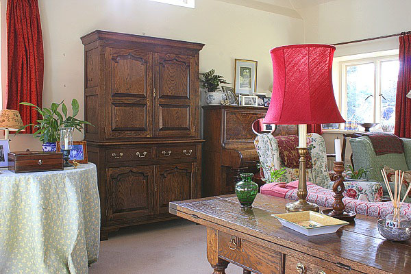 Oak panelled storage cupboard in sitting room of Surrey cottage.