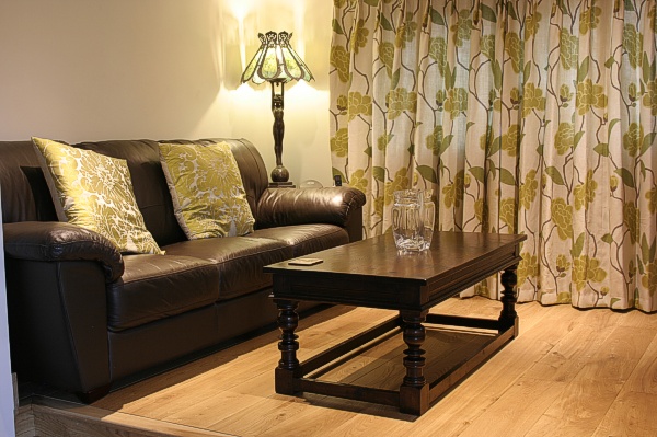 Period style dark oak coffee table in snug of Sussex country house.