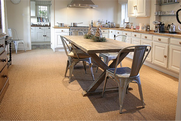 Scrubbed oak x-leg dining table in kitchen of Surrey country house.