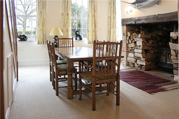 Oak refectory table and spindleback chairs in dining room of Norfolk country house.