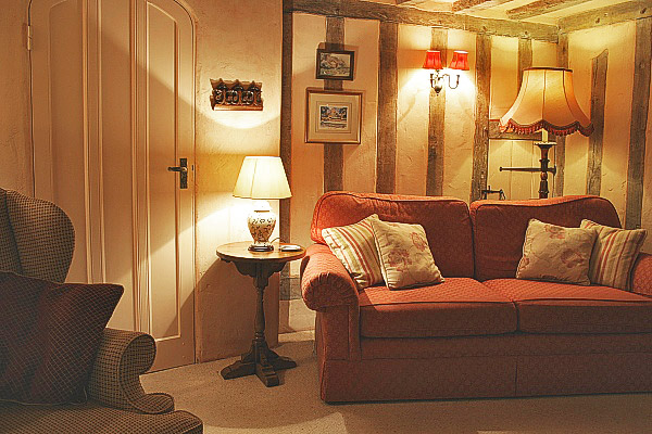 Period style round oak lamp table in timber framed sitting room.