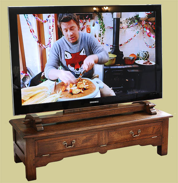 Traditional styled oak TV stand, with drop down fielded panel false drawer, and bespoke oak TV mount.