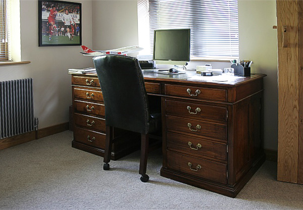 Bespoke cherry wood pedestal desk in clients study.