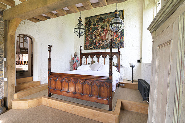 Gothic style carved oak bed in converted chapel of 14th century Sussex manor house.