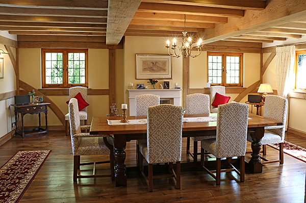 Bespoke heavy oak extending table, with our fully upholstered side chairs and carvers, in our clients oak framed and beamed extension.