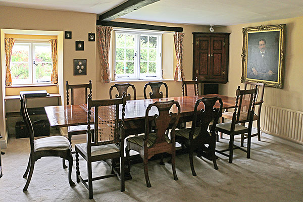 Oak extending pedestal dining table, in the dining room of our clients West Sussex village cottage, with their eclectic mix of antique walnut side chairs and armchairs.