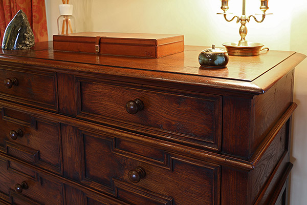 Detail of late 17th century style oak chest of drawers, with geometric cushion moulded drawer fronts.