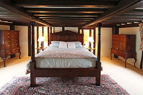 Carved oak bed in heavily beamed 16th century bedroom