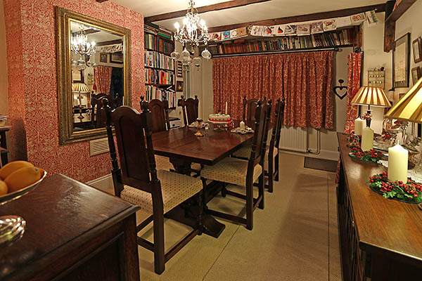 Period style dining table and upholstered chairs in oak beamed Sussex cottage.