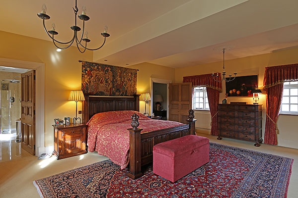 Oak hand carved linenfold bed and matching bedside cupboard, in the master bedroom of our clients Warwickshire country home.