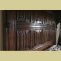 Linenfold panelled headboard detail of half tester, or part four-poster oak bed.