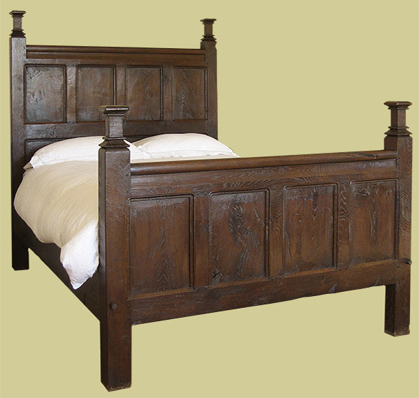 Period style oak panelled bed with square cut posts finials.