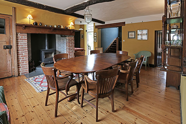 Extending twin pedestal oak table, in dining room of converted period pub.