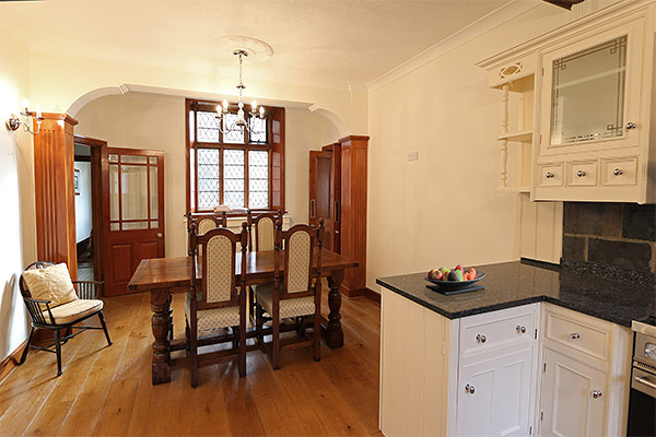 Oak refectory table and upholstered chairs in historic manor house.