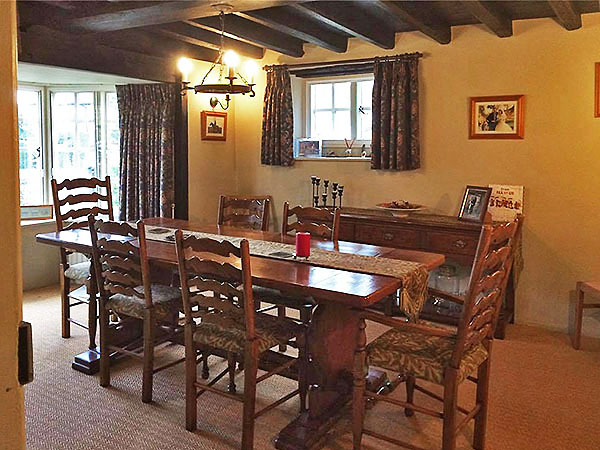 Restored antique table and chairs with oak potboard dresser base, in old manor house.