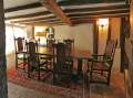Period style oak pedestal dining table and chairs in ancient beamed room