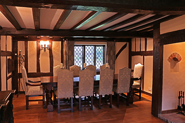 Period style oak table and upholstered chairs in 17th century Sussex cottage