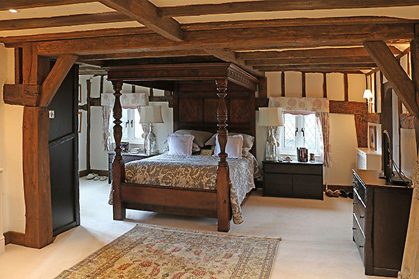 17th century style carved oak tester bed in Surrey cottage
